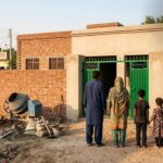 Newly built house with a family at the gate under the Apni Chhat Apna Ghar scheme in Punjab