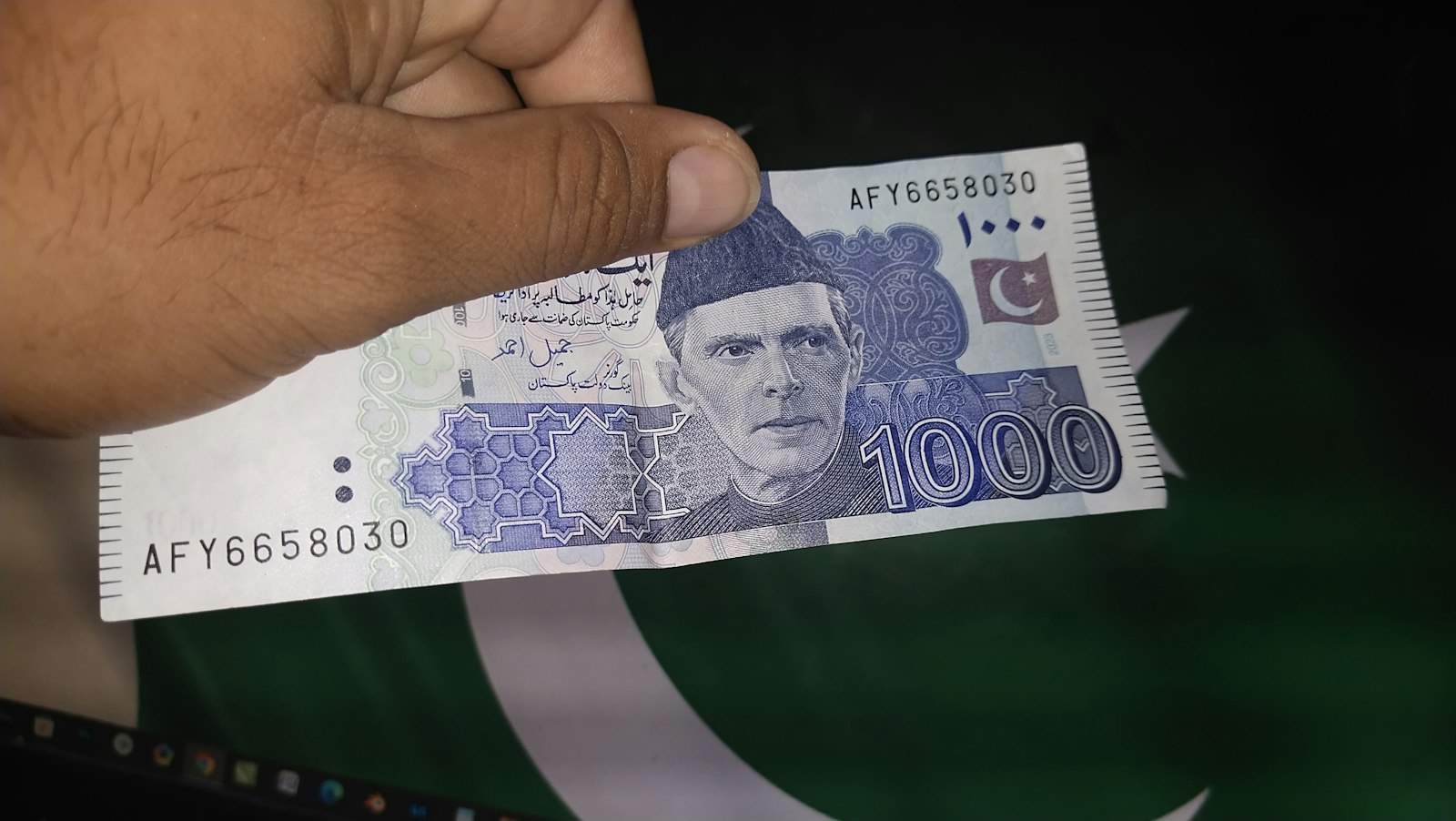Remittances to Pakistan – a hand holding a Pakistani 100 rupee note
