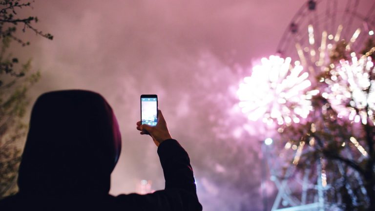 Tecno Camon 40 price in Pakistan – representational image of a person taking a night photo with a smartphone